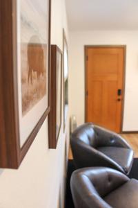 una silla de cuero junto a una pared con una foto en Cabin 4 at Horse Creek Resort en Rapid City