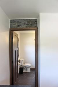 an open door to a bathroom with a toilet at Cabin 4 at Horse Creek Resort in Rapid City