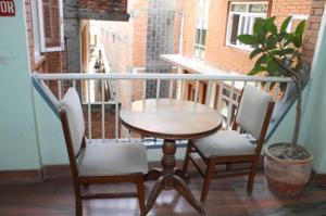 a table and two chairs on a balcony at Mount Annapurna Guest House in Kathmandu