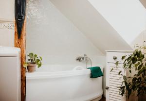ein Bad mit einer Badewanne im Dachgeschoss in der Unterkunft Libling Podkrovný in Banská Štiavnica