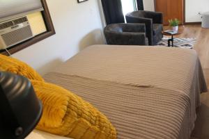 a bedroom with a bed and a chair in a room at Cabin 5 at Horse Creek Resort in Rapid City