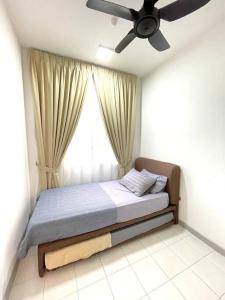 Bett in einem Zimmer mit Deckenventilator in der Unterkunft Maryam’s House (Lovely Seaview apartment ) in Kuala Terengganu