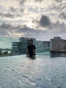 a man standing in a pool of water at Maryam’s House (Lovely Seaview apartment ) in Kuala Terengganu