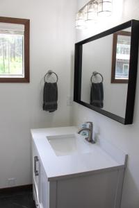 a bathroom with a white sink and a mirror at Cabin 6 at Horse Creek Resort in Rapid City