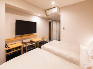 Un pat sau paturi într-o cameră la Sotetsu Fresa Inn Daimon