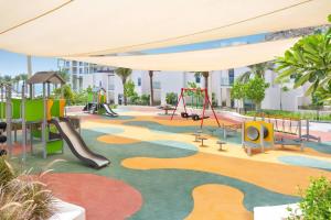 a playground with a slide and swings at Luxurious apartment at address residences in Fujairah
