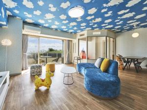 a living room with a blue couch and clouds painted on a ceiling at Village Izukogen in Ito