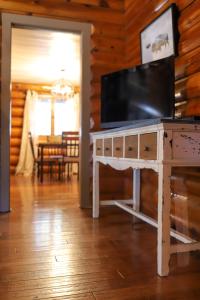 a living room with a tv on top of a table at Historic Log Cabin #14 at Horse Creek Resort in Rapid City