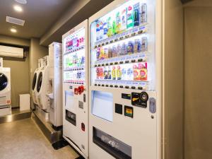 una gran máquina expendedora blanca con bebidas. en Sotetsu Fresa Inn Daimon, en Tokio