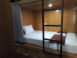 a bedroom with two bunk beds and a mirror at Hastina Hotel Lombok in Mataram