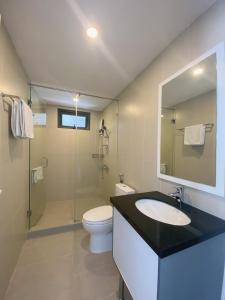 La salle de bains est pourvue d'un lavabo, de toilettes et d'un miroir. dans l'établissement Hachi Home, à Đà Nẵng