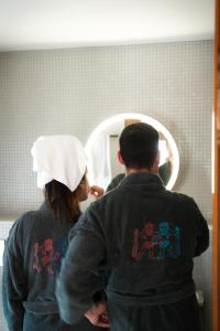 Ein Mann und eine Frau sehen in einen Spiegel in der Unterkunft Le Sauvage in Freiburg im Üechtland