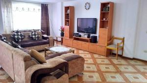 sala de estar con 2 sofás y TV de pantalla plana en Casas Danadri, Como En Casa en Riobamba