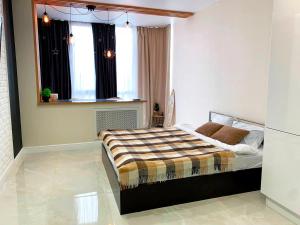 a bedroom with a bed in a room with a window at Studio Black&White in Voronezh