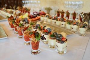a table topped with glasses filled with appetizers and desserts at Грейс Абрис in Adler