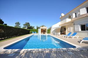 een villa met een zwembad voor een huis bij Large 6 bedroom private pool villa in Vilasol Resort in Quarteira