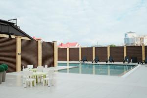 a patio with a table and chairs next to a pool at Грейс Абрис in Adler