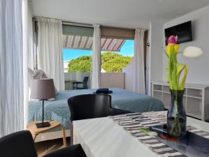 een hotelkamer met een bed en een tafel met een vaas met bloemen bij studio 38 climatisé balcon vue mer in Le Grau-du-Roi