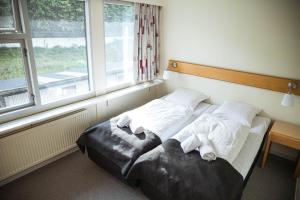 um quarto com 2 camas em frente a uma janela em Hotel Runavík em Runevig