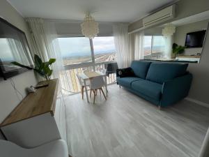 a living room with a blue couch and a table at Four Seasons in Empuriabrava