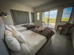 En eller flere senger på et rom på Uukwaluudhi Safari Lodge