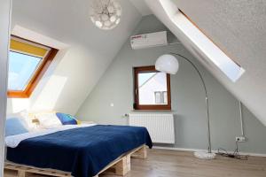 a bedroom with a blue bed in a attic at Gemütliche 2 Zimmerwohnung mit TV und WLAN in Wendlingen am Neckar