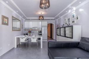 a living room with a black couch and a kitchen at Perlamar in Calpe