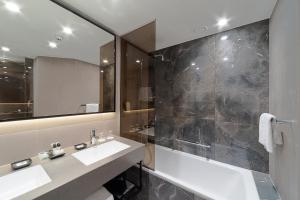 a bathroom with a sink and a shower and a mirror at Holiday Inn Helsinki - Expo, an IHG Hotel in Helsinki