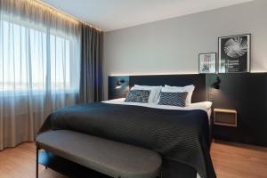 um quarto com uma cama grande e uma janela em Holiday Inn Helsinki - Expo, an IHG Hotel em Helsinque