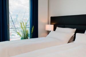 a bedroom with two beds and a window with a harbor at Ostsee - Maisonette - Appartement Nr 54 "Marina-Blick" im Strand Resort in Heiligenhafen