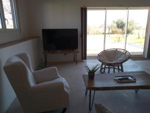 a living room with a tv and a couch and a table at l'airial in Souprosse +21 photos