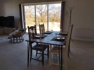 a dining room table and chairs with a table and a window at l'airial in Souprosse
