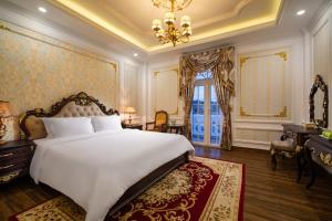 a bedroom with a large white bed and a chandelier at Dream Boutique Hotel in Da Lat +31 photos