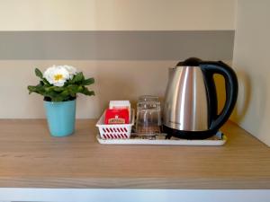 a coffee pot and a vase on a wooden table at B&B Tra i Laghi in Casale Corte Cerro
