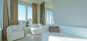 sala de estar con sofá, silla y ventanas en Hotel Cristallo, en Riccione