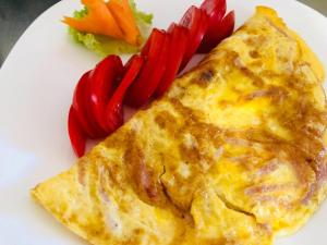 a white plate with a omelet and vegetables on it at Mireasma Bucovinei Apartment in Crucea
