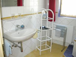 a bathroom with a white sink and a shelf at Ferienhaus Feuerer in Obertraun