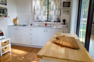 a kitchen with a wooden table and a sink at Bandalong Cottages in Mudgee