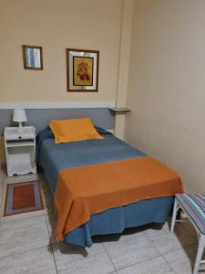 een slaapkamer met een bed met een oranje deken bij Apartamento Olaya in Candelaria