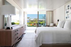 a bedroom with a large bed and a large window at Four Seasons Astir Palace Hotel Athens in Athens