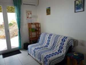 a bedroom with a bed with a striped comforter and a window at la belle bleue in Banyuls-sur-Mer