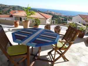 a table and chairs on a balcony with a view at la belle bleue in Banyuls-sur-Mer