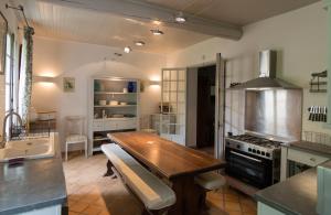 eine Küche mit Holztisch und Herd in der Unterkunft La Marisol in LʼIsle-sur-la-Sorgue