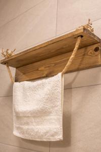 a wooden towel rack hanging on a wall at AVLA LUXURY HOSPITALITY in Karpathos