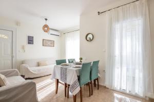 AVLA LUXURY HOSPITALITY في كارباثوس: غرفة معيشة بيضاء مع طاولة وكراسي