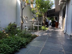 a patio with a table and chairs on a sidewalk at Border Close Guesthouse in Upington