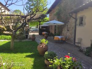 einen Garten mit einem Tisch und einem Sonnenschirm in der Unterkunft Albergo Casentino in Poppi