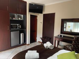 a bedroom with a bed with towels on it at Border Close Guesthouse in Upington