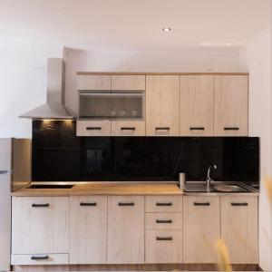 uma cozinha com armários de madeira e um forno com placa de fogão em Kanoni Garden House em Kanoni