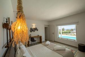 a bedroom with a bed and a desk and a window at Villa Paraga in Platis Gialos